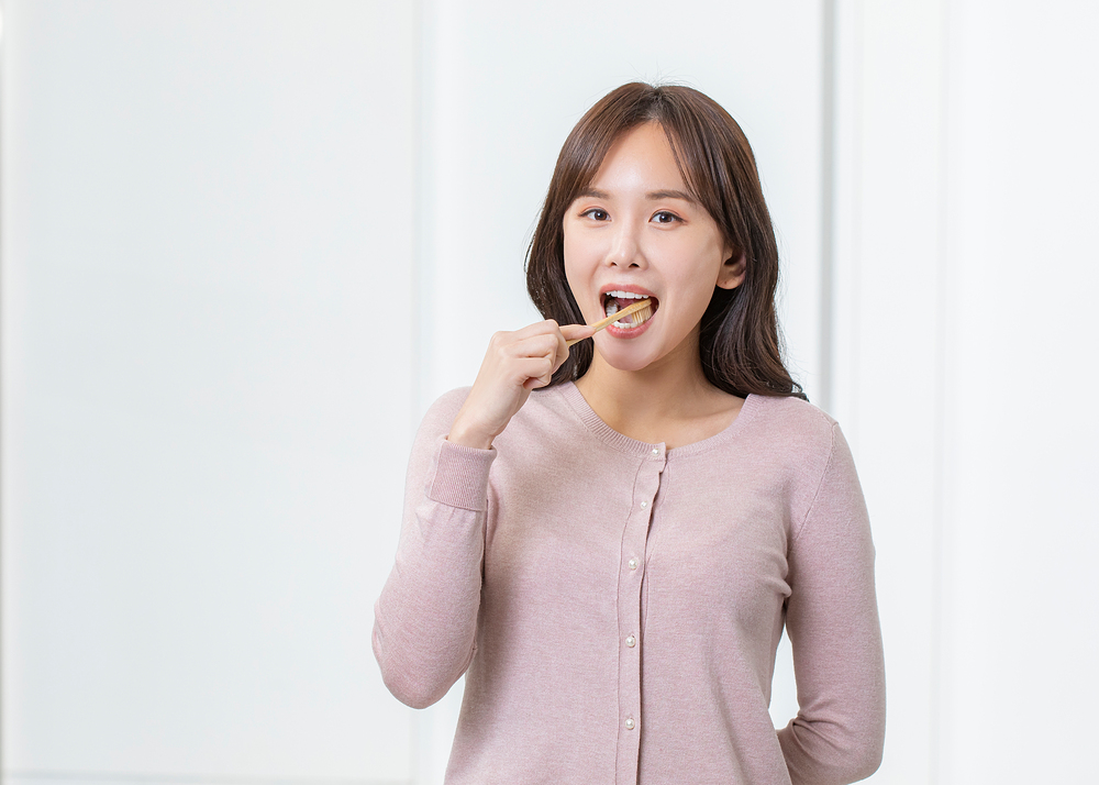 칫솔로 양치질을 하고 있는 중년 여성