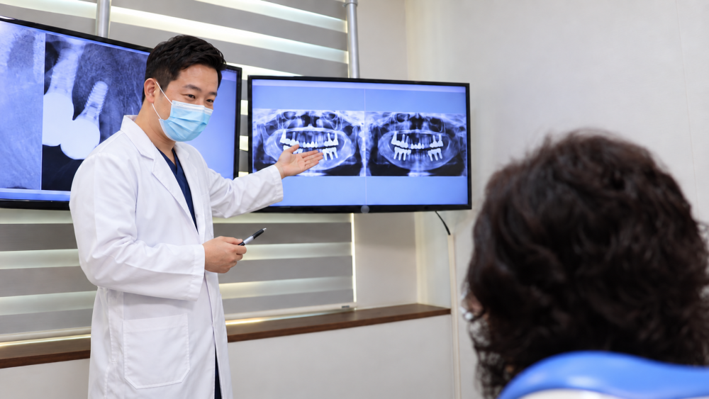 삼계뉴욕치과병원 김원태 원장이 화면의 임플란트 엑스레이를 보며 환자에게 설명하는 모습